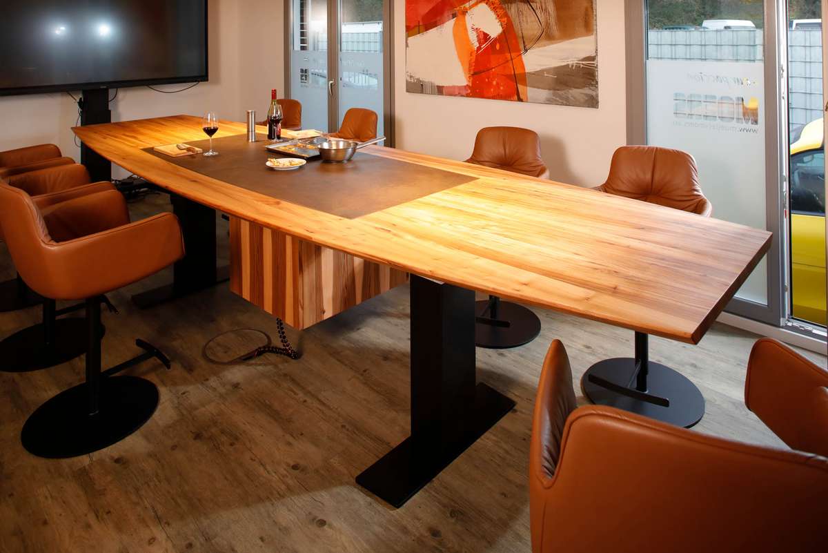 Der höhenverstellbare Konferenztisch mit unsichtbarem Kochfeld in Rüster